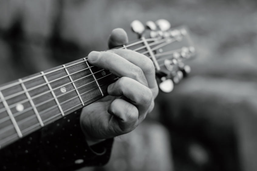 monochrome photo of playing a guiter